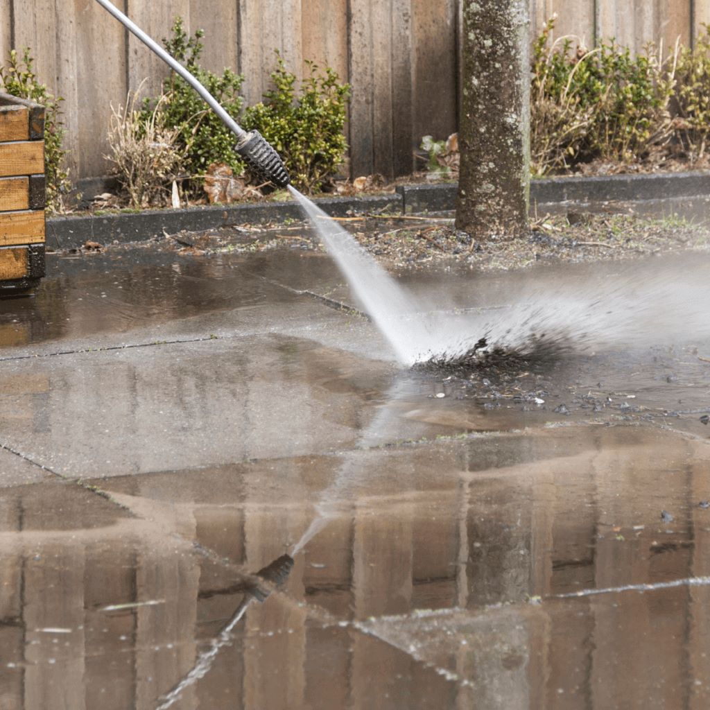 power washing the ground with a pressure washer